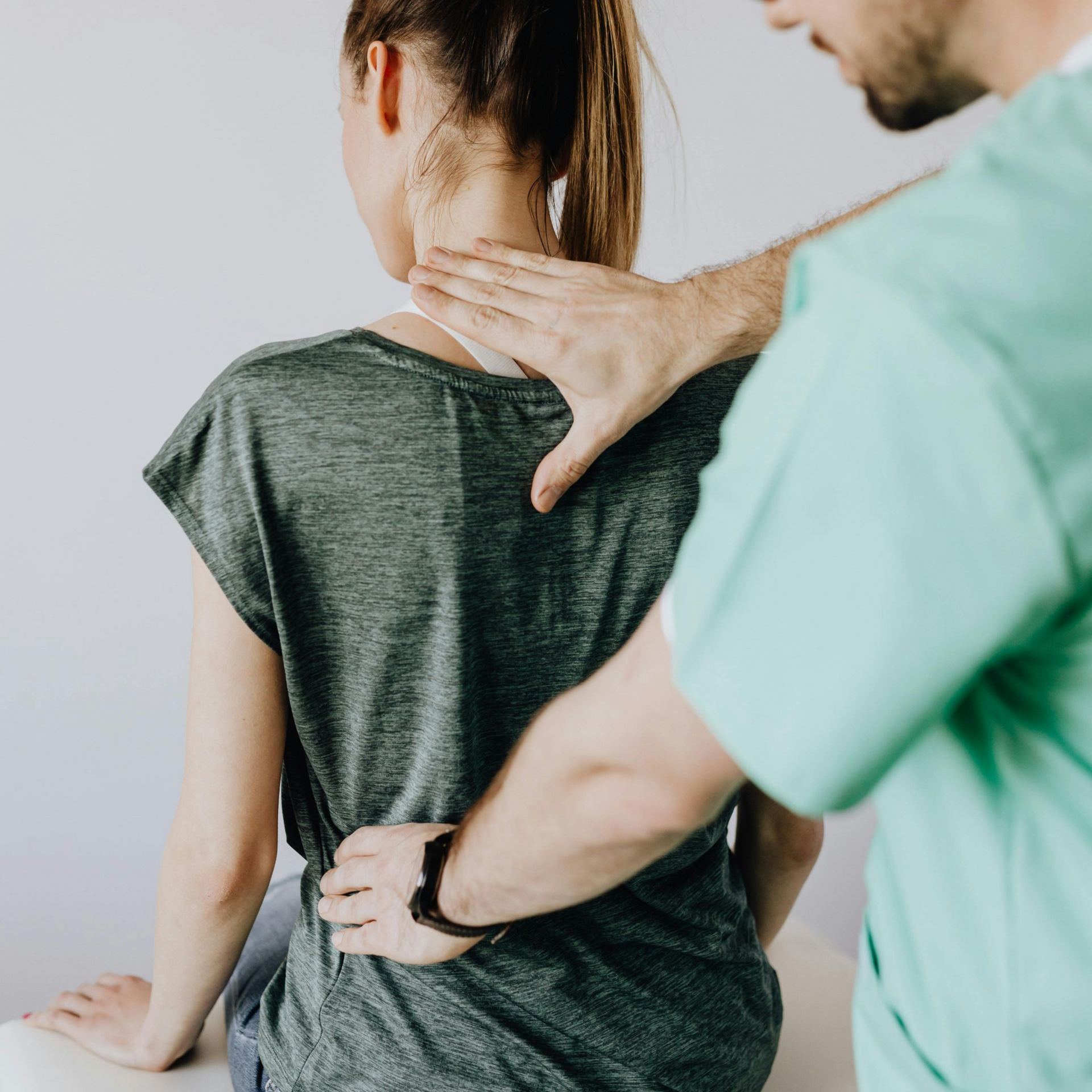 Chiropractor examining a patient seated on a treatment table